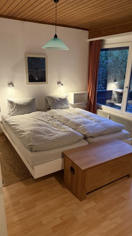 Doppelbett im Obergeschoss mit Holztruhe am Fussende