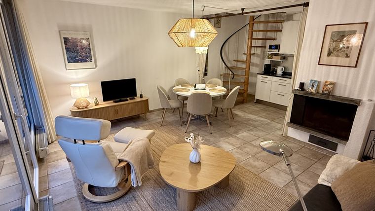 Wohnbereich mit Sessel, Fernseher, Essplatz und Cheminée