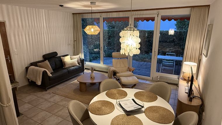 Wohnzimmer am Abend mit Fensterfront zum Gartensitzplatz